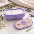 Load image into Gallery viewer, Purple candle with 'Texan Crafts' branding on a light surface with lavender and herbs.
