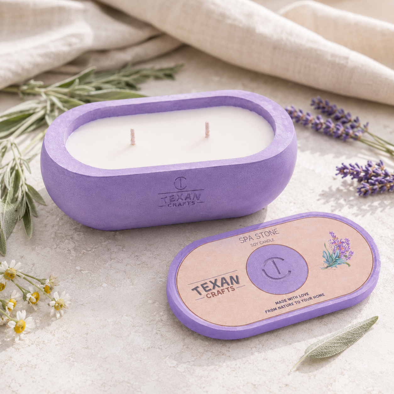 Purple candle with 'Texan Crafts' branding on a light surface with lavender and herbs.